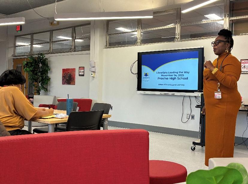 A person stands near a screen displaying “Librarians Leading the Way, November 16, 2025, Provine High School.”