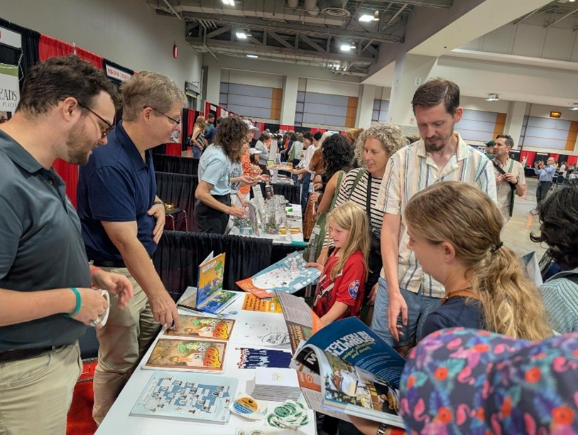 Busy event booth with red and black curtains labeled ‘Mississippi’ and ‘Missouri,’ where attendees gather to view displays and collect materials.